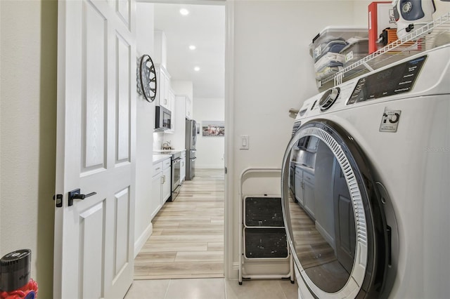 9577 Sandy Bluffs Cir, Parrish, FL 34219 - washroom featuring recessed lighting, light tile patterned floors, and independent washer and dryer