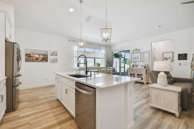 9577 Sandy Bluffs Cir, Parrish, FL 34219 - kitchen featuring appliances with stainless steel finishes, light countertops, light wood-style floors, and white cabinetry
