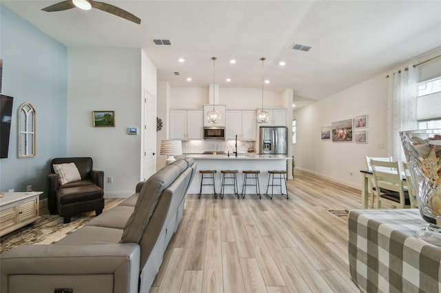 9577 Sandy Bluffs Cir, Parrish, FL 34219 - living room with light wood-type flooring, ceiling fan, recessed lighting, and vaulted ceiling