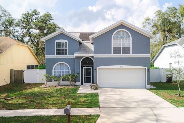 2318 Kenwick Dr, Valrico, FL 33596 - traditional-style home featuring a gate, an attached garage, driveway, a shingled roof, and stucco siding
