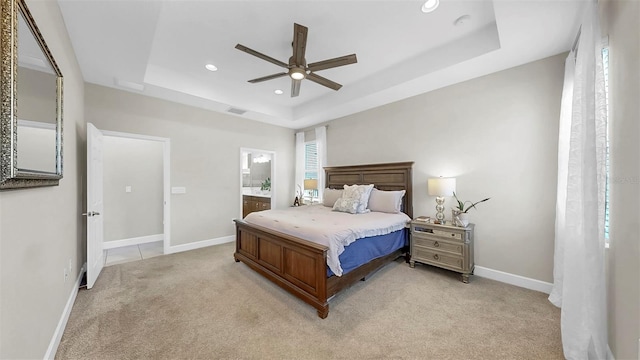 6118 Voyagers Pl, Apollo Beach, FL 33572 - bedroom featuring a tray ceiling, light colored carpet, recessed lighting, connected bathroom, and a ceiling fan