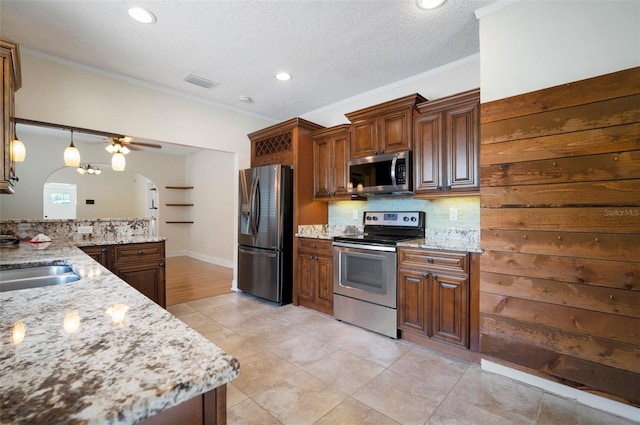 6419 S Englewood Ave, Tampa, FL 33611 - kitchen featuring appliances with stainless steel finishes, tasteful backsplash, arched walkways, light stone countertops, and crown molding