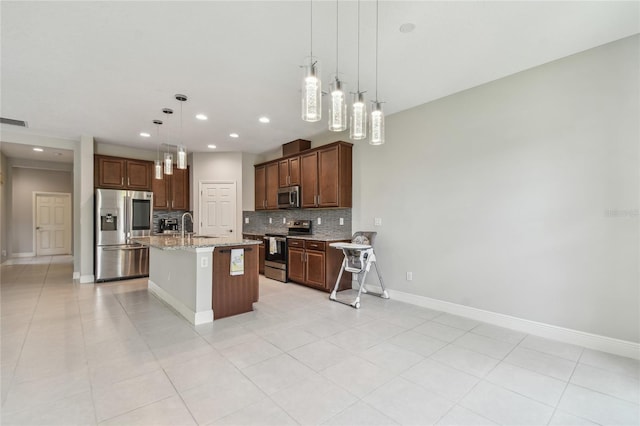 13311 Dorado Shores Ave, Riverview, FL 33579 - kitchen featuring appliances with stainless steel finishes, decorative backsplash, a sink, baseboards, and a center island with sink