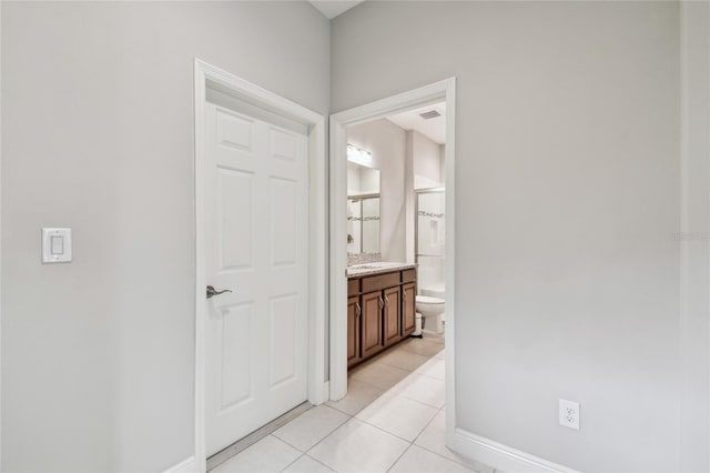 13311 Dorado Shores Ave, Riverview, FL 33579 - corridor featuring light tile patterned floors, baseboards, and a sink