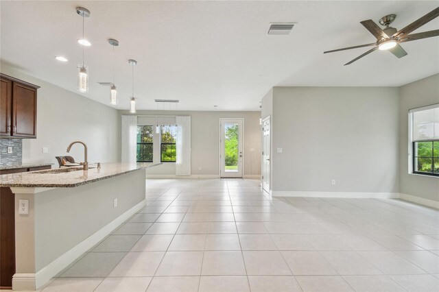 13311 Dorado Shores Ave, Riverview, FL 33579 - kitchen featuring open floor plan, a sink, plenty of natural light, and light stone countertops