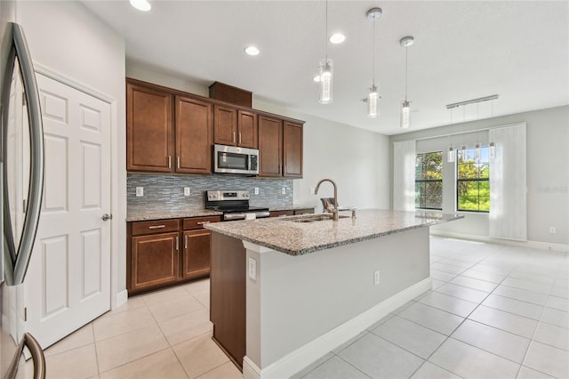 13311 Dorado Shores Ave, Riverview, FL 33579 - kitchen with stainless steel appliances, a sink, light tile patterned floors, light stone countertops, and backsplash