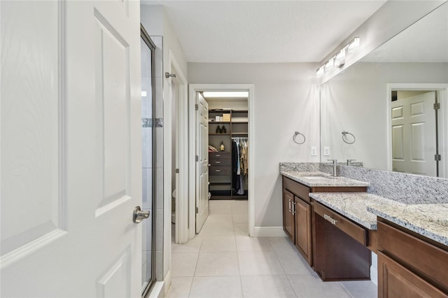 13311 Dorado Shores Ave, Riverview, FL 33579 - bathroom featuring vanity, a spacious closet, a stall shower, tile patterned floors, and baseboards