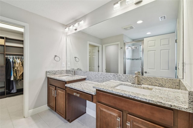 13311 Dorado Shores Ave, Riverview, FL 33579 - bathroom featuring double vanity, a shower stall, tile patterned floors, and a walk in closet