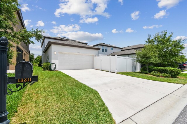13311 Dorado Shores Ave, Riverview, FL 33579 - view of front facade with driveway, stucco siding, roof mounted solar panels, and an attached garage