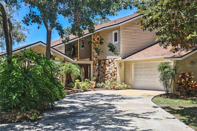 12929 Sugar Creek Blvd, Hudson, FL 34669 - view of front facade featuring stone siding, concrete driveway, a garage, and roof with shingles