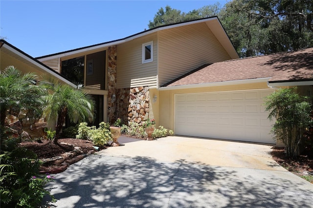 12929 Sugar Creek Blvd, Hudson, FL 34669 - mid-century home with driveway, stone siding, an attached garage, and roof with shingles
