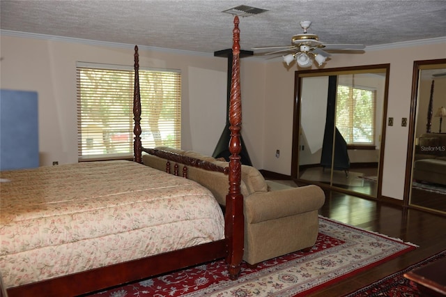 12929 Sugar Creek Blvd, Hudson, FL 34669 - bedroom with multiple windows, hardwood / wood-style flooring, crown molding, two closets, and a textured ceiling