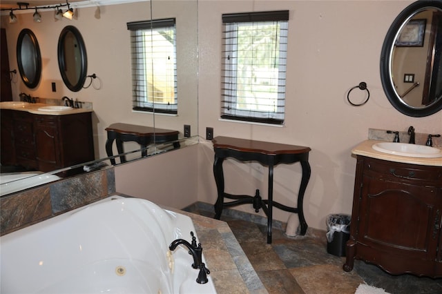 12929 Sugar Creek Blvd, Hudson, FL 34669 - full bath with a tub with jets, two vanities, and stone finish floors