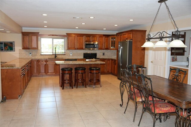 12929 Sugar Creek Blvd, Hudson, FL 34669 - kitchen featuring appliances with stainless steel finishes, brown cabinetry, ornamental molding, a center island, and recessed lighting