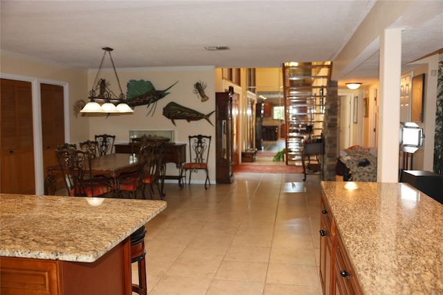 12929 Sugar Creek Blvd, Hudson, FL 34669 - kitchen featuring light tile patterned floors, brown cabinetry, a breakfast bar area, and ornamental molding