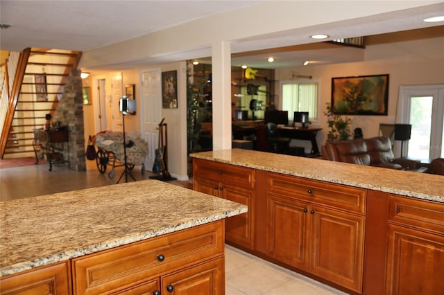 12929 Sugar Creek Blvd, Hudson, FL 34669 - kitchen featuring light stone counters, brown cabinetry, and light tile patterned flooring