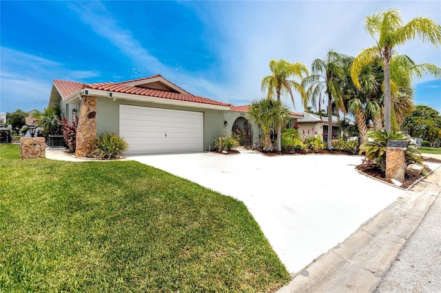 9909 San Mateo Way, Port Richey, FL 34668 - mediterranean / spanish home with stucco siding, driveway, a front yard, a garage, and a tile roof