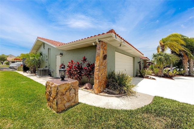 9909 San Mateo Way, Port Richey, FL 34668 - view of property exterior featuring a garage, a tiled roof, a yard, central air condition unit, and driveway