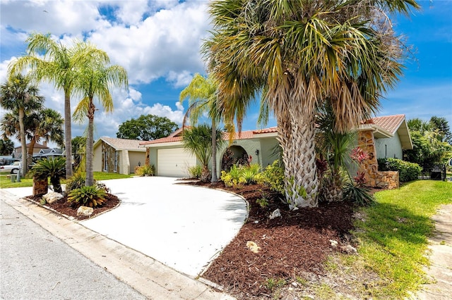 9909 San Mateo Way, Port Richey, FL 34668 - mediterranean / spanish-style house featuring driveway, an attached garage, stucco siding, and a tiled roof