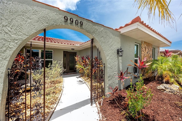 9909 San Mateo Way, Port Richey, FL 34668 - view of front facade with a tiled roof and stucco siding