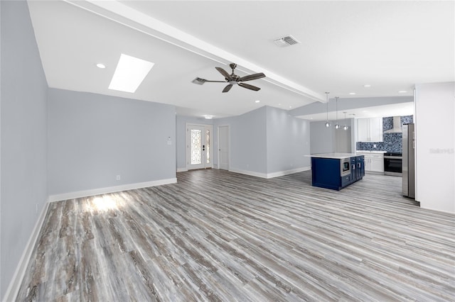 9909 San Mateo Way, Port Richey, FL 34668 - unfurnished living room with light wood-type flooring, ceiling fan, baseboards, and recessed lighting