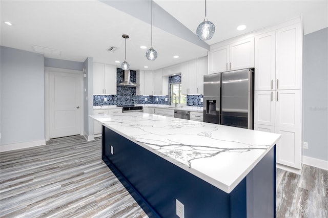 9909 San Mateo Way, Port Richey, FL 34668 - kitchen with appliances with stainless steel finishes, wall chimney range hood, light wood-style flooring, baseboards, and white cabinets