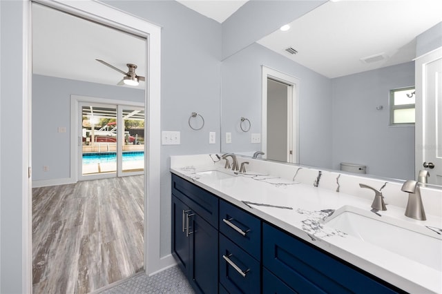 9909 San Mateo Way, Port Richey, FL 34668 - bathroom featuring healthy amount of natural light, double vanity, toilet, and baseboards