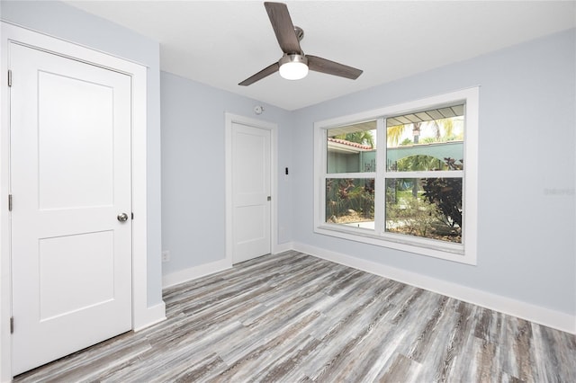9909 San Mateo Way, Port Richey, FL 34668 - unfurnished bedroom featuring wood finished floors, baseboards, and a ceiling fan