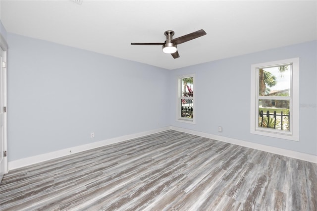 9909 San Mateo Way, Port Richey, FL 34668 - spare room with wood finished floors, healthy amount of natural light, a ceiling fan, and baseboards