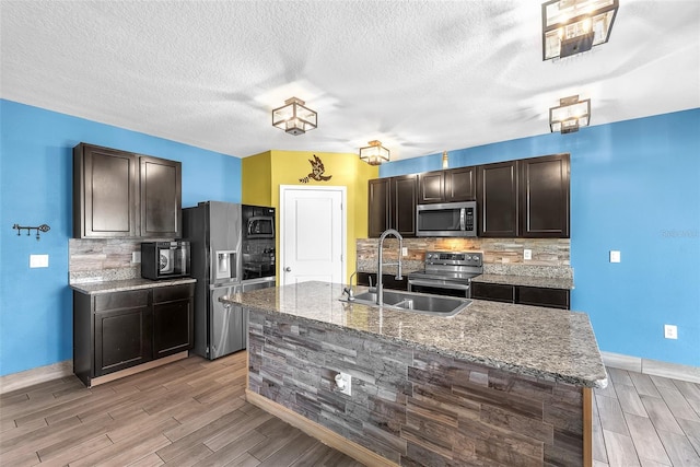 14135 Arbor Pines Dr, Riverview, FL 33579 - kitchen with stainless steel appliances, a sink, wood finish floors, baseboards, and backsplash