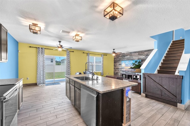 14135 Arbor Pines Dr, Riverview, FL 33579 - kitchen featuring appliances with stainless steel finishes, ceiling fan, a sink, wood tiled floors, and a textured ceiling