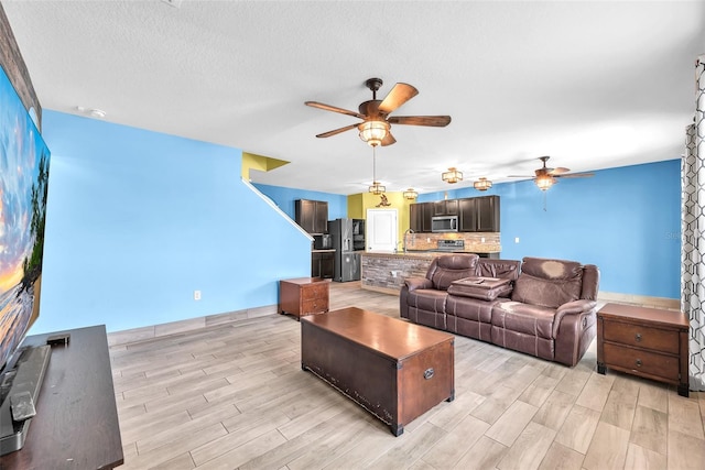 14135 Arbor Pines Dr, Riverview, FL 33579 - living area featuring ceiling fan, light wood finished floors, and a textured ceiling