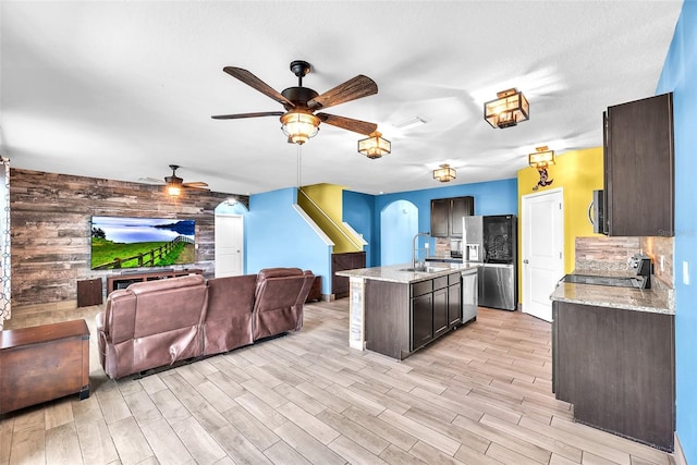 14135 Arbor Pines Dr, Riverview, FL 33579 - kitchen featuring appliances with stainless steel finishes, ceiling fan, open floor plan, a sink, and light wood-type flooring
