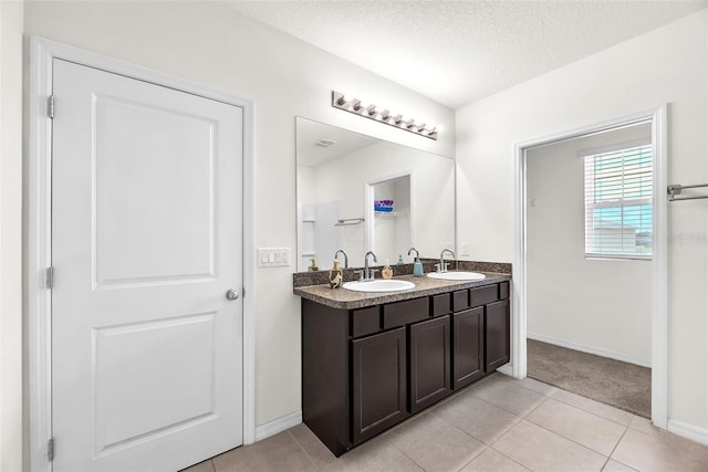 14135 Arbor Pines Dr, Riverview, FL 33579 - bathroom featuring a textured ceiling, double vanity, tile patterned floors, and baseboards