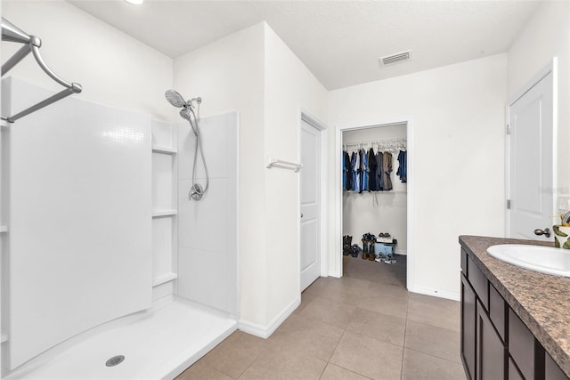 14135 Arbor Pines Dr, Riverview, FL 33579 - bathroom with walk in shower, vanity, baseboards, tile patterned flooring, and a spacious closet
