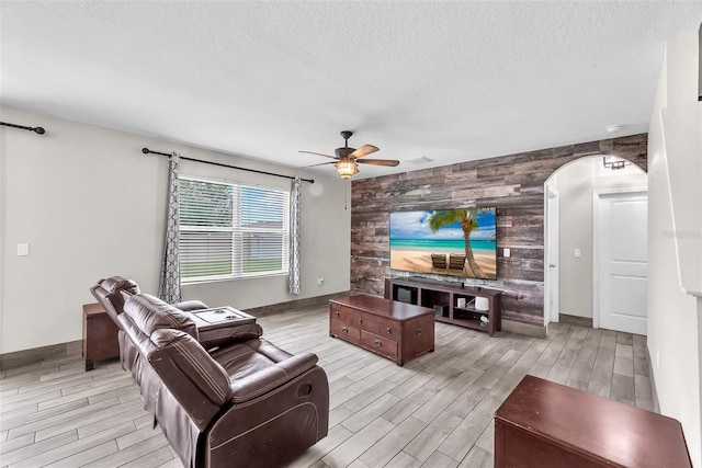 14135 Arbor Pines Dr, Riverview, FL 33579 - living room with an accent wall, wood walls, wood tiled floors, ceiling fan, and a textured ceiling