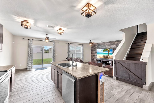 14135 Arbor Pines Dr, Riverview, FL 33579 - kitchen featuring a ceiling fan, stainless steel appliances, wood tiled floors, a textured ceiling, and a center island with sink