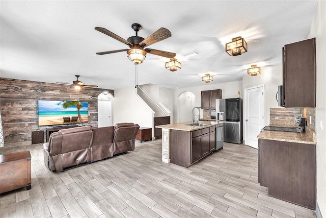 14135 Arbor Pines Dr, Riverview, FL 33579 - kitchen with stainless steel appliances, ceiling fan, wood walls, dark brown cabinets, and open floor plan