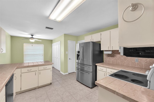 11816 Cedarfield Dr, Riverview, FL 33579 - kitchen featuring stainless steel appliances, decorative backsplash, white cabinetry, ceiling fan, and tile countertops