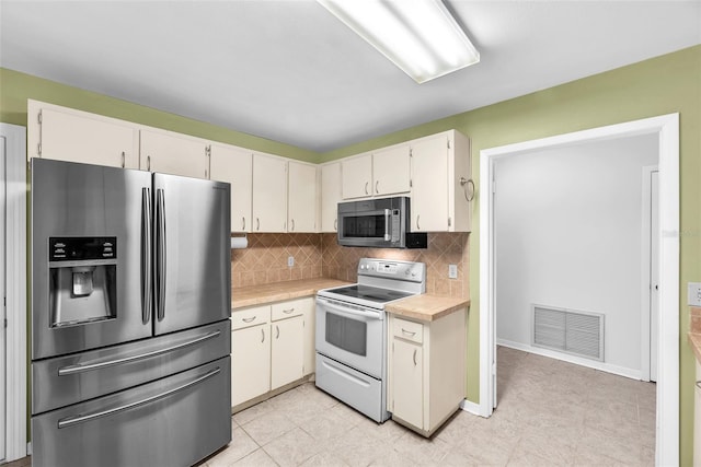 11816 Cedarfield Dr, Riverview, FL 33579 - kitchen with appliances with stainless steel finishes, light countertops, backsplash, and white cabinetry
