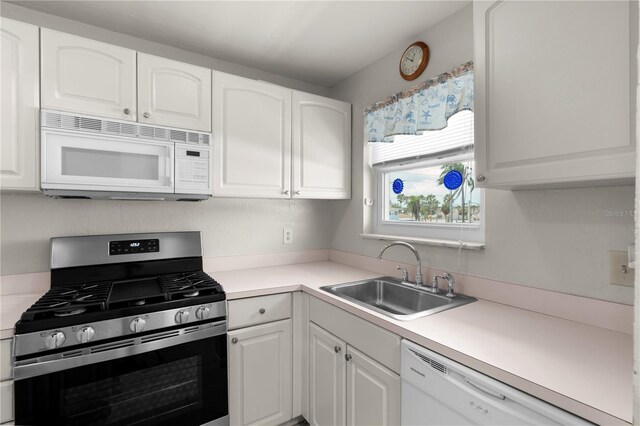 3114 59th St S Unit 203, Gulfport, FL 33707 - kitchen featuring white appliances, a sink, and white cabinetry