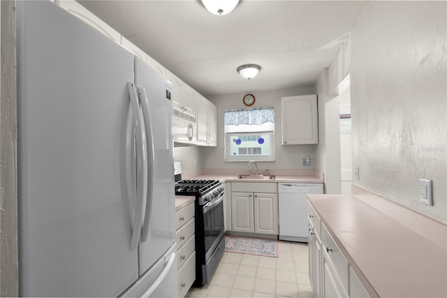 3114 59th St S Unit 203, Gulfport, FL 33707 - kitchen with white appliances, a sink, light countertops, white cabinets, and light tile patterned flooring