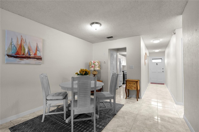 3114 59th St S Unit 203, Gulfport, FL 33707 - dining space with a textured ceiling and baseboards