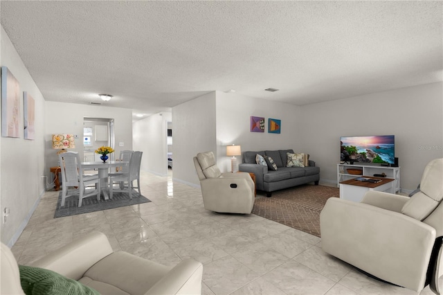 3114 59th St S Unit 203, Gulfport, FL 33707 - living room with a textured ceiling, light marble finish flooring, and baseboards