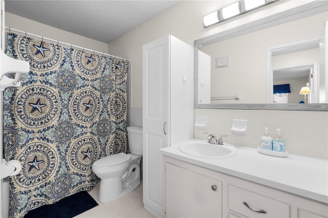 3114 59th St S Unit 203, Gulfport, FL 33707 - bathroom featuring toilet, vanity, tile patterned floors, tasteful backsplash, and a textured ceiling