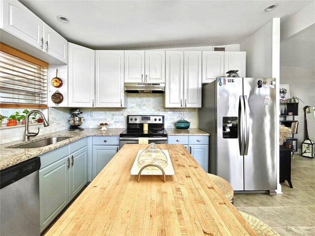 6700 14th St N, Saint Petersburg, FL 33702 - kitchen with stainless steel appliances, a sink, under cabinet range hood, wood counters, and decorative backsplash