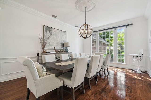 16502 Millan De Avila, Tampa, FL 33613 - dining area featuring a chandelier, dark wood-style floors, crown molding, a decorative wall, and wainscoting