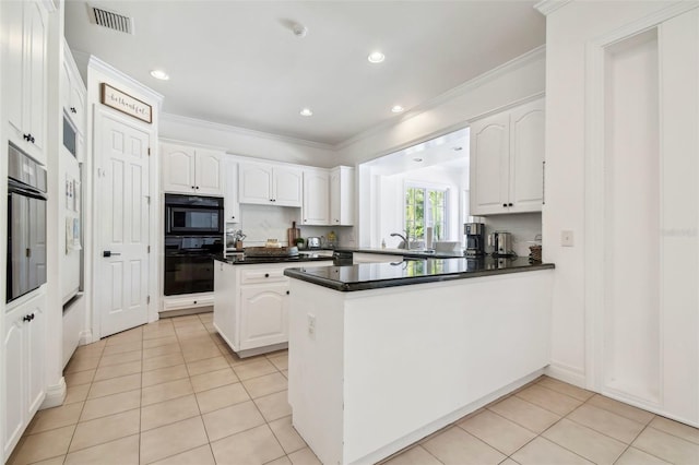 16502 Millan De Avila, Tampa, FL 33613 - kitchen featuring light tile patterned floors, a peninsula, white cabinets, dark countertops, and crown molding