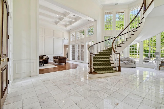 16502 Millan De Avila, Tampa, FL 33613 - entryway featuring a towering ceiling, a decorative wall, coffered ceiling, stairway, and light marble finish floors