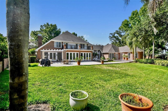 16502 Millan De Avila, Tampa, FL 33613 - rear view of house featuring french doors, a patio, a lawn, and brick siding